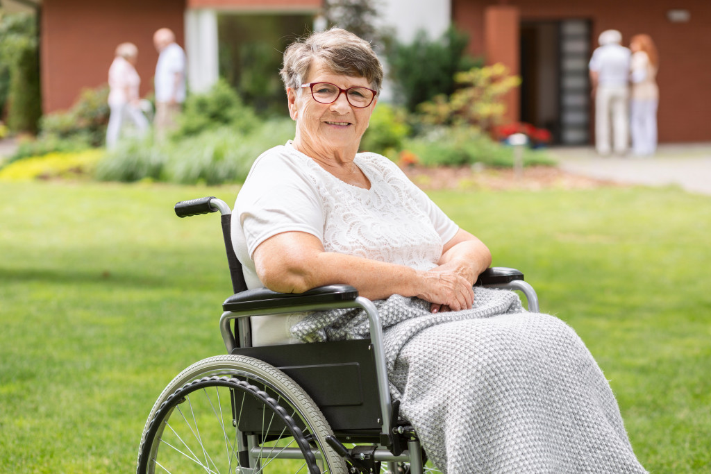 senior lady on her wheelchair strolling inside the care facility